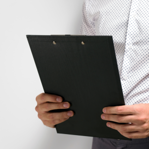 Man holds clipboard that has an essential checklist for fire safety solutions